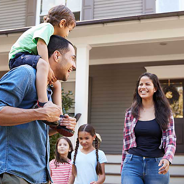A happy family standing in front of their home.