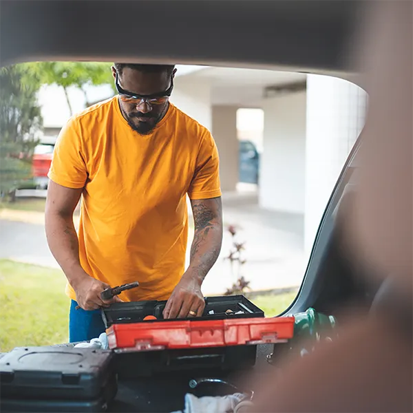 A man looking through an open toolbox.