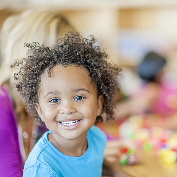 A smiling child looking at the camera.