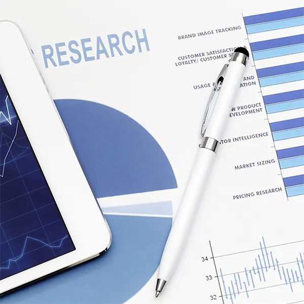 A pen and a tablet lying on top of a paper report titled 'research.'