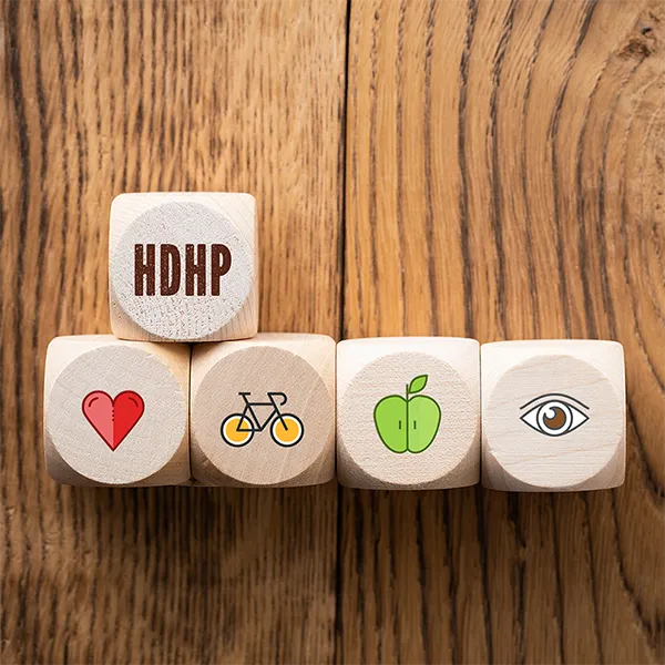 Five wooden blocks. Four have health-related icons, and one has the letters 'HDHP.'