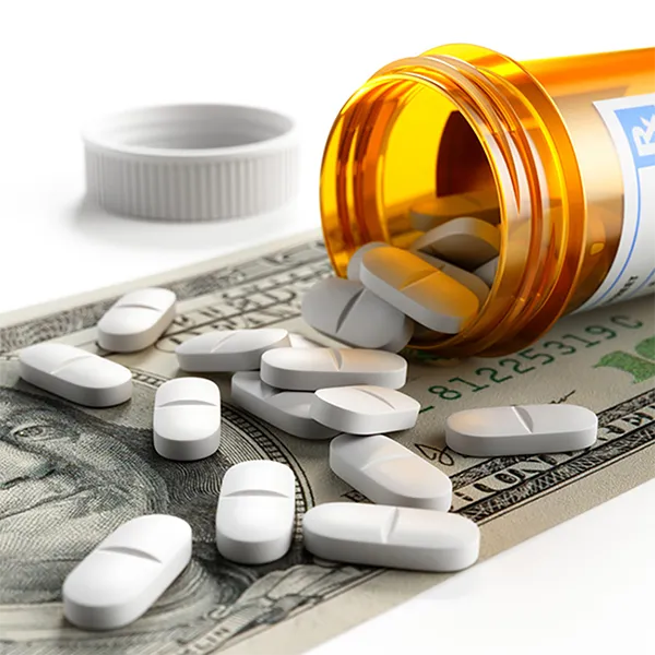 A pile of 100 dollar bills with a stethoscope on top of them.