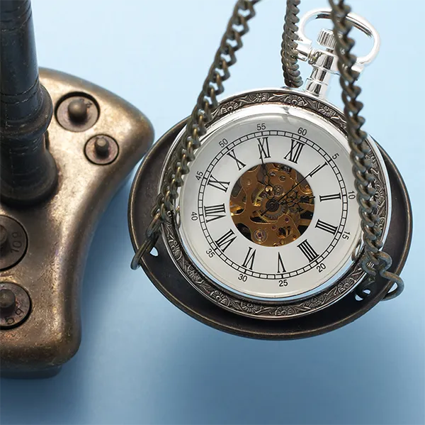 A pocket watch and a stack of money on opposite sides of a balance scale.