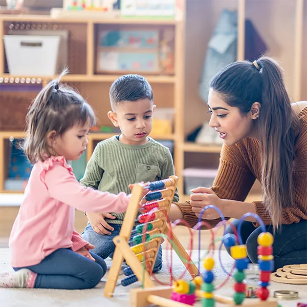 A childcare worker with a group of young children.