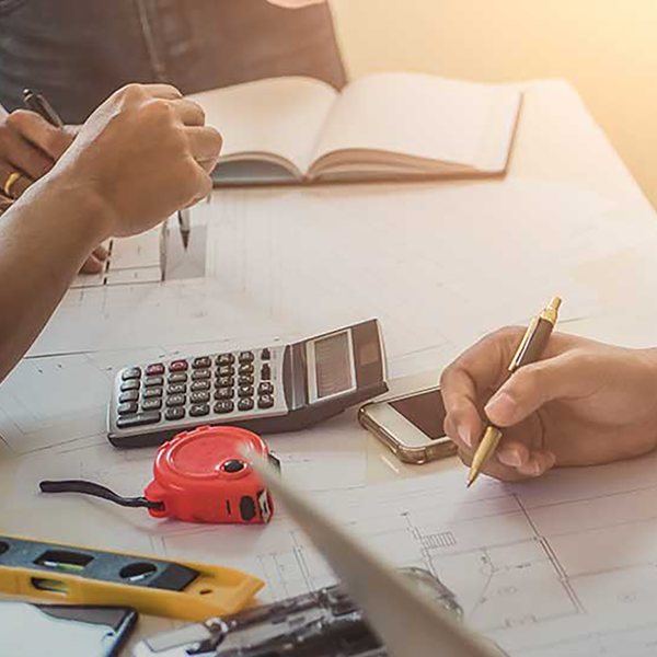 A contractor making notes on a blueprint.