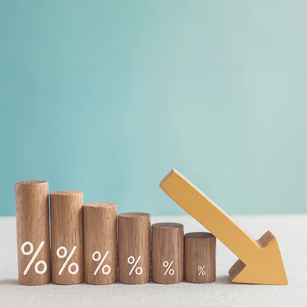 Wooden blocks stacked to mimic a bar graph with an arrow pointing down.