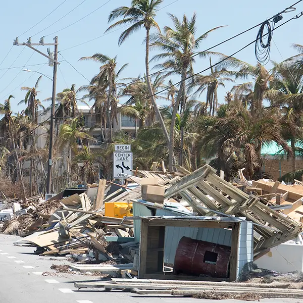 Rubble from a knocked-down building beside a city street.