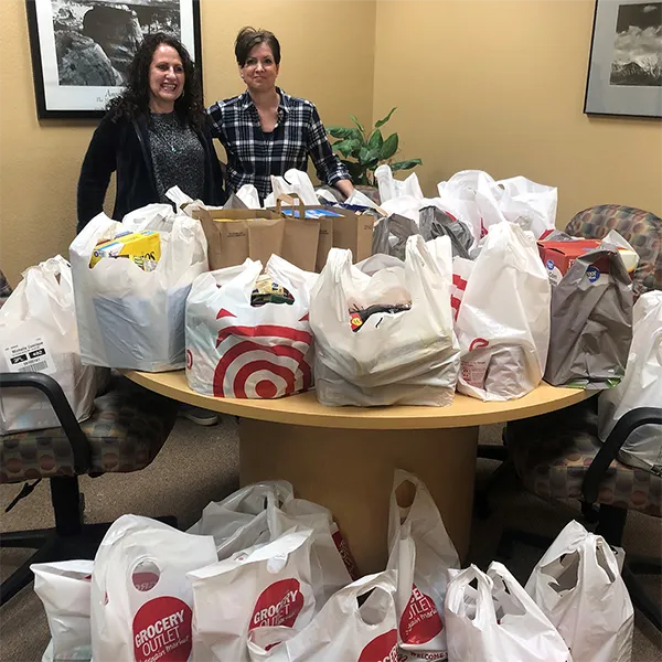Two team members from the InterWest Hollister Office with holiday donations.