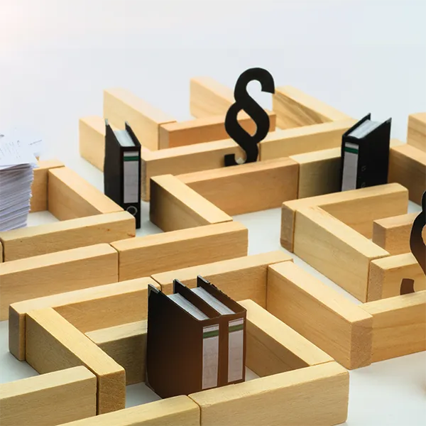 A maze made out of blocks with binders and papers throughout the maze.