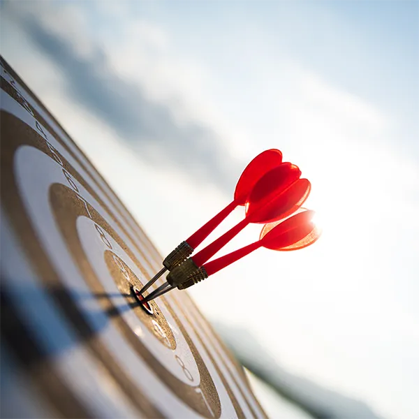 A close-up of darts in the center of a dartboard.