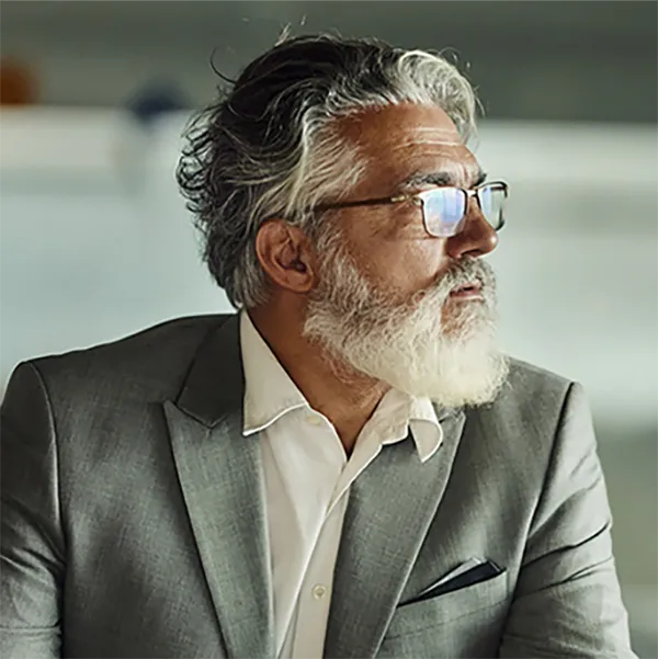 A businessman looking pensively at text reading 'To Stay or Not To Stay?'