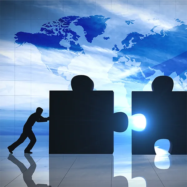 Two people push large puzzle pieces together.