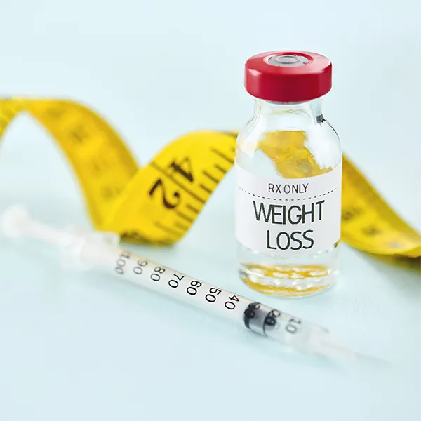 A syringe and medicine bottle labeled weight loss.