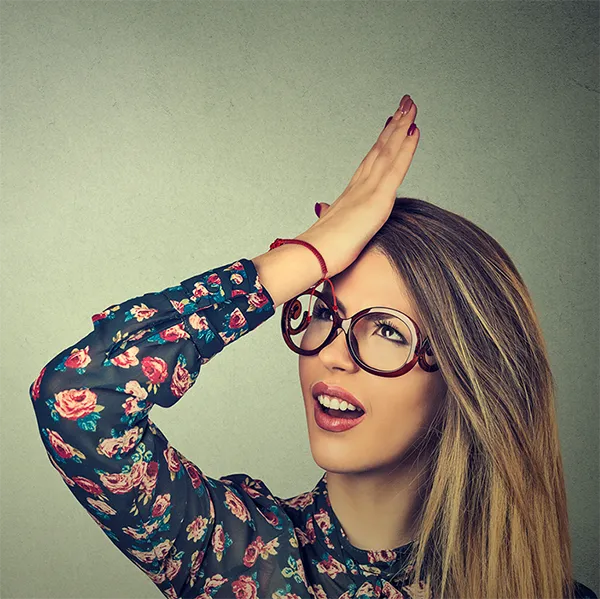 A woman pressing her palm to her forehead in frustration.
