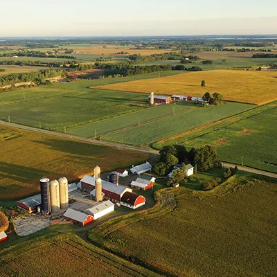 An aerial image of a farm fields, barns and silos.