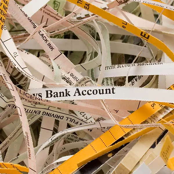 Shreds of paper, one of which reads 'bank account.'