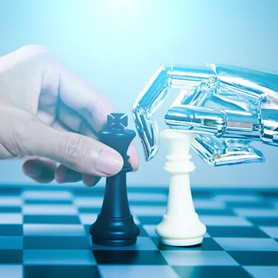 A human hand and a robot hand each grabbing a chess piece on a chess board.