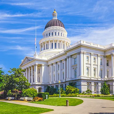 A photo of the California State Capitol building taken at an angle on a bright sunny day.