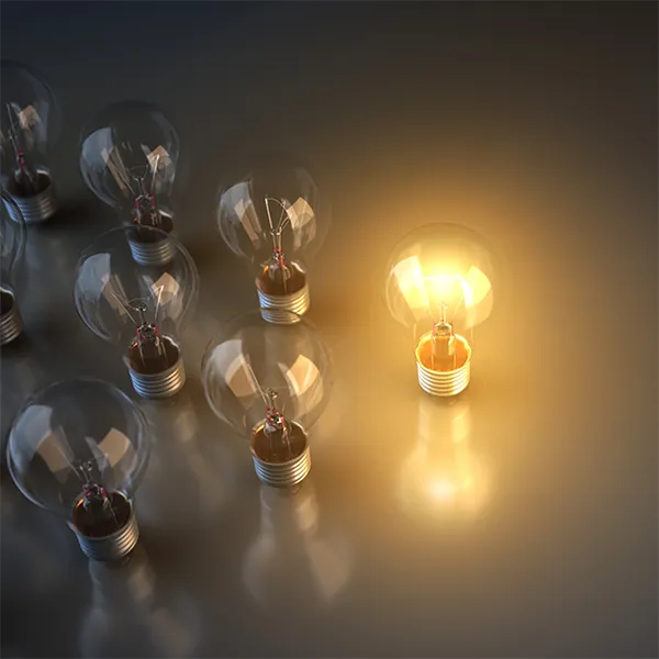A group of lightbulbs. One is illuminated.