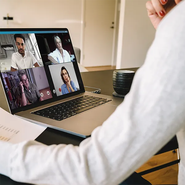 A woman reading a report while participating in a video conference.