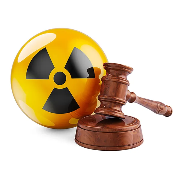 A gavel and sounding block in front of a yellow and black radiation symbol.