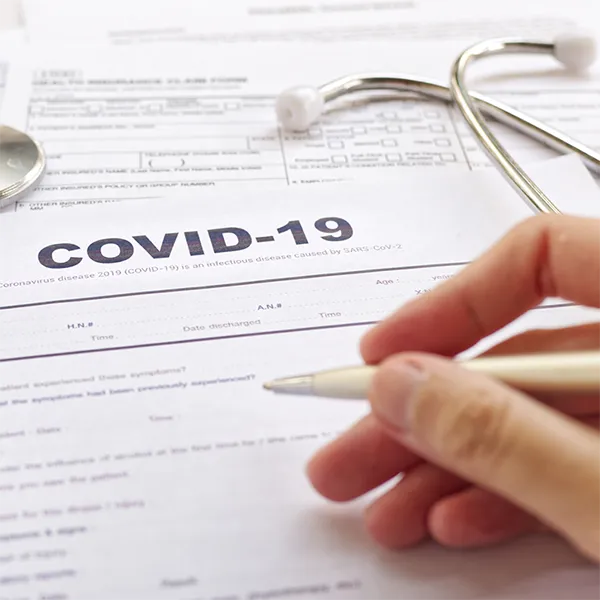 Someone filling out a form titled 'COVID-19.'
