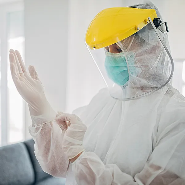 A person wearing personal protective equipment including gloves and a face mask.