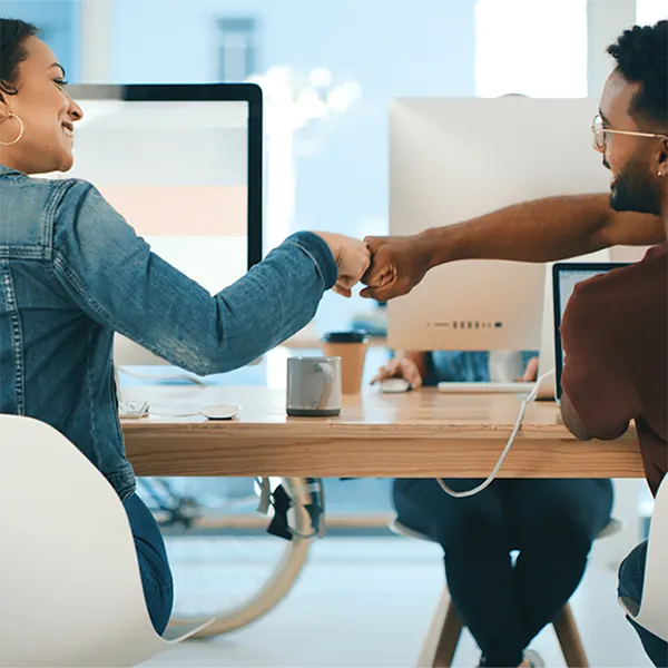 A pair of professionals fist bumping.