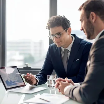 Two insurance professionals discussing a report.