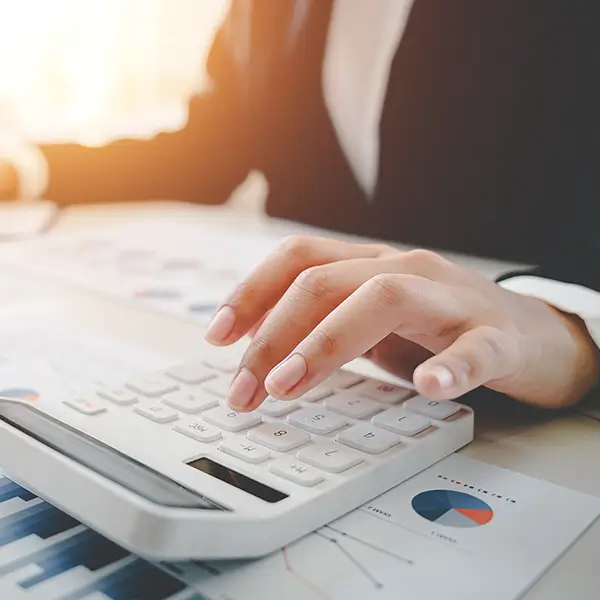 Two professionals looking at report data and using a calculator.