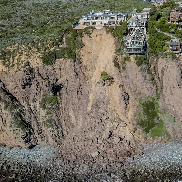 A large home on the edge of a cliff that looks unstable.