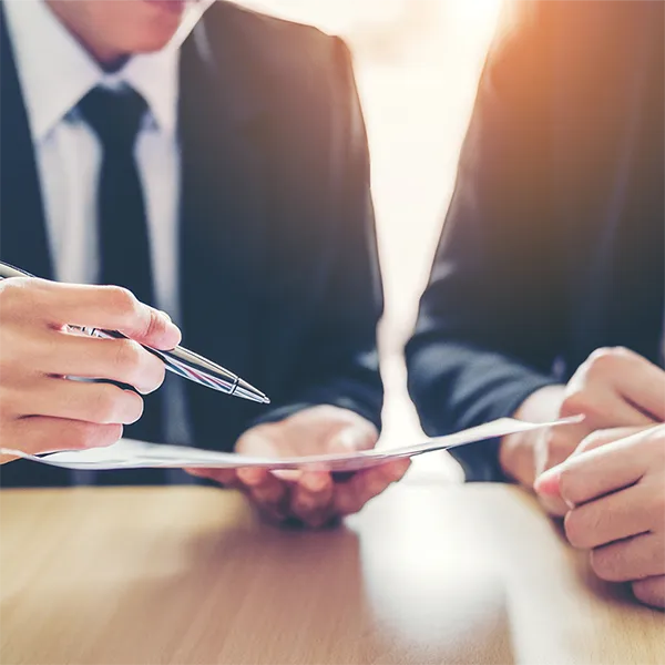 People wearing suits filling out paperwork.