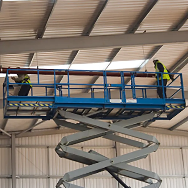 A pair of construction workers on a scissor lift.