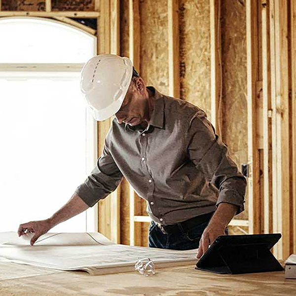 A construction worker reviewing blueprints.
