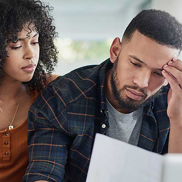 A couple reviewing insurance documents looking stressed.