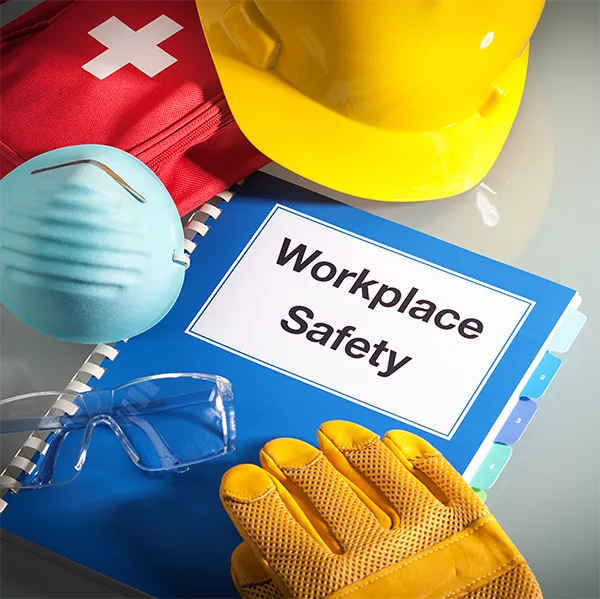 A booklet surrounded by equipment. The booklet reads 'Workplace Safety.'