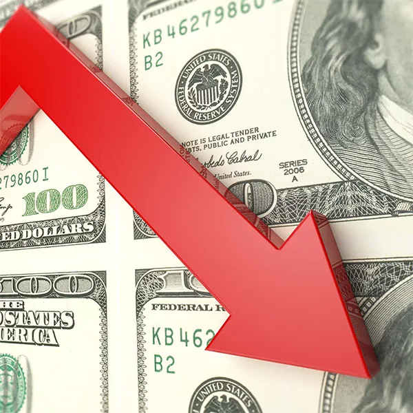 A red line pointing down in front of a series of $100 bills.