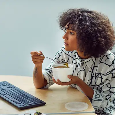 worker eating lunch on her desk