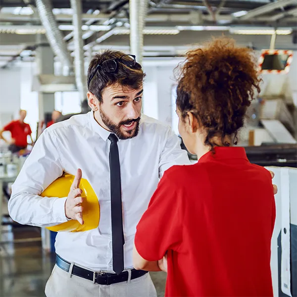 Two professionals arguing in a factory environment.