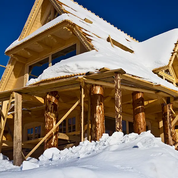 A home made of wood covered in snow.