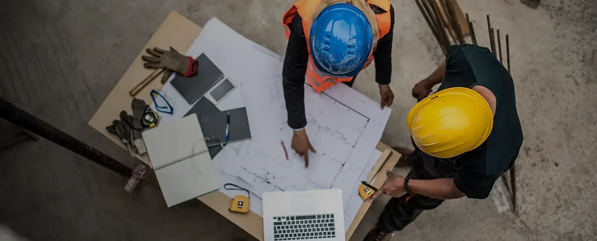 people in a hardhats looking at blueprints