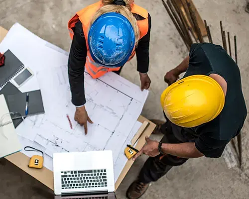 people in a hardhats looking at blueprints