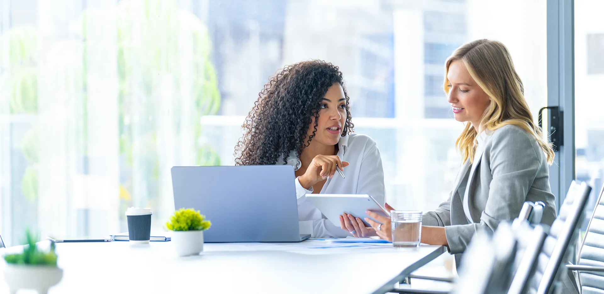 two women discussing work on a ipad