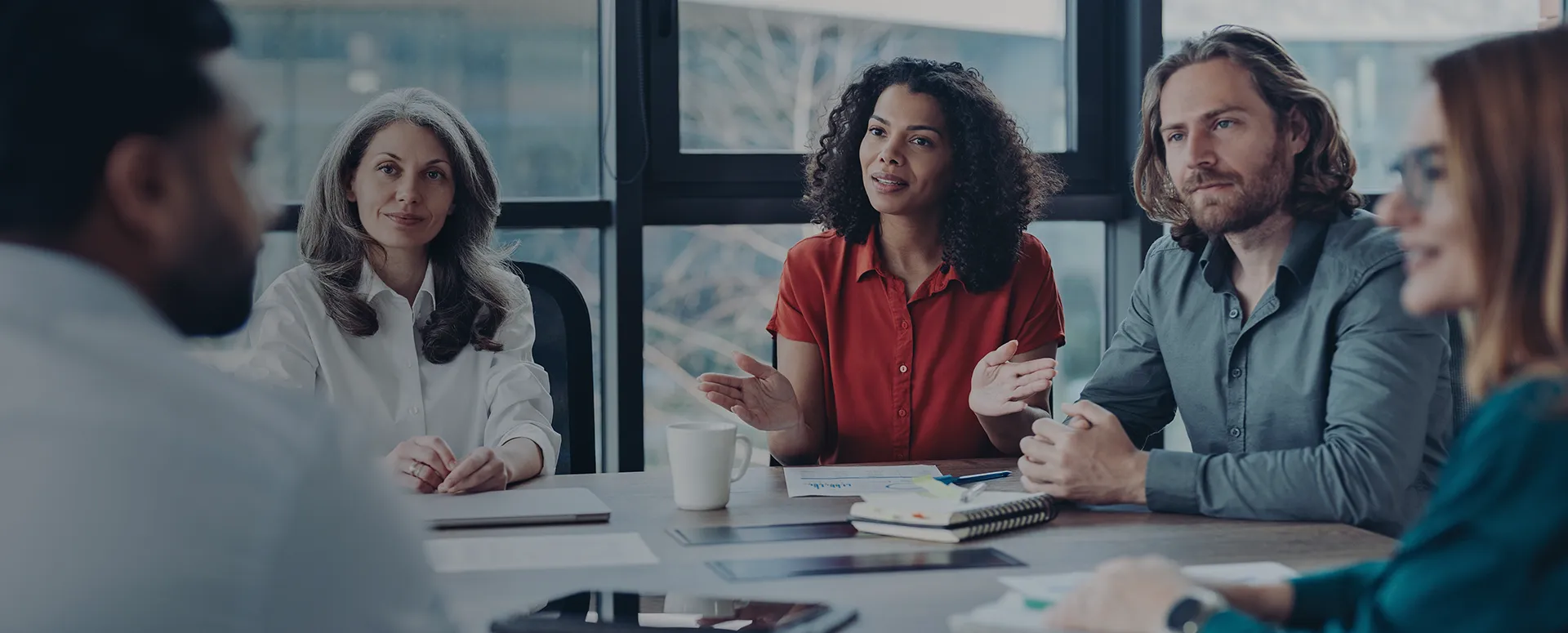A team of people sitting at a conference table during a meeting.
