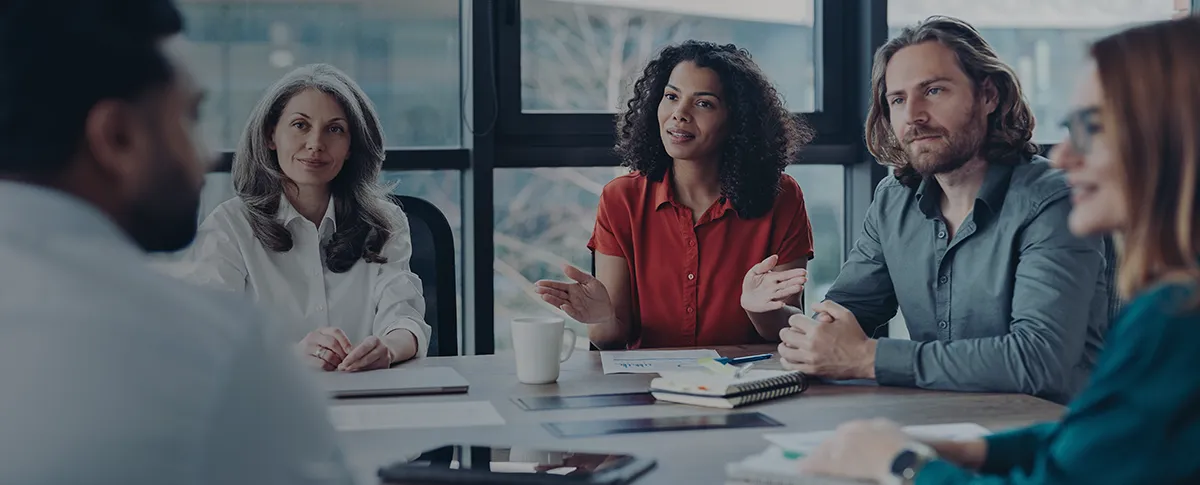 A team of people sitting at a conference table during a meeting.