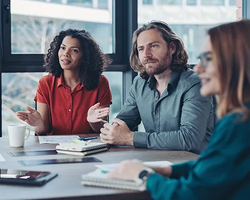 A team of people sitting at a conference table during a meeting.