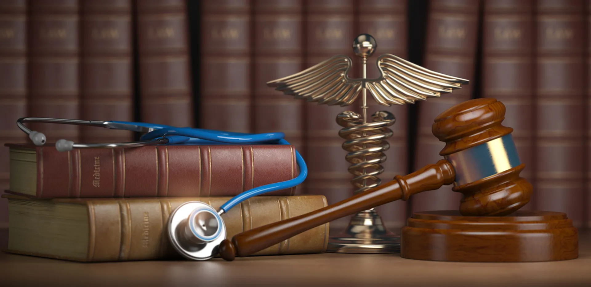 Legal volumes, a stethoscope, a medical caduceus, and a judges gavel on a desk.
