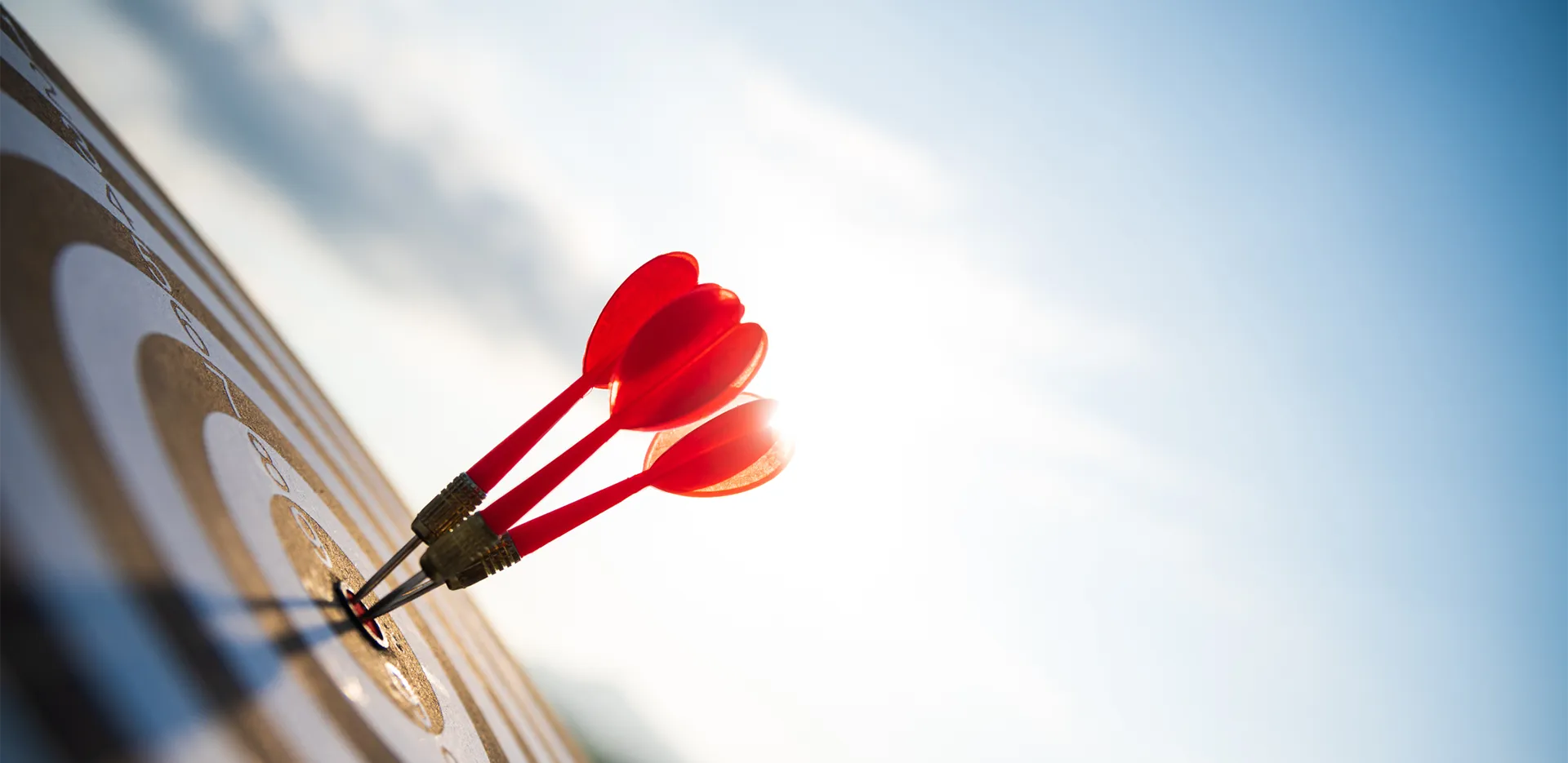 A close-up of darts in the center of a dartboard.