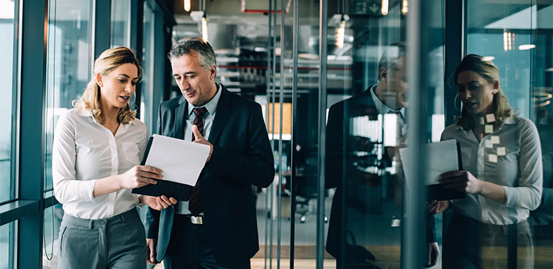Two professionals reviewing information on a clipboard.
