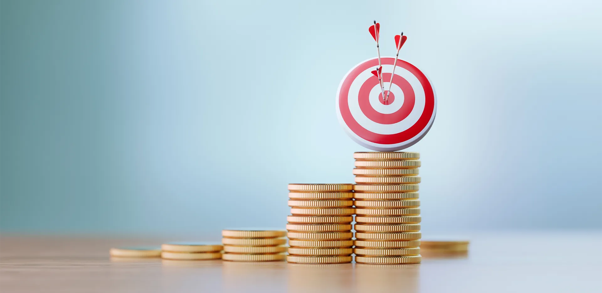A rendering of a dart board and darts behind stacks of gold coins.